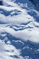 two people are hiking up a mountain with snow covered mountains photo