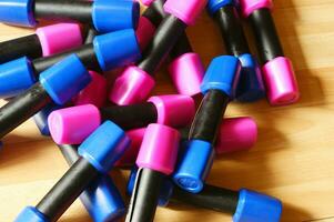 a pile of blue and pink plastic toys on a wooden floor photo