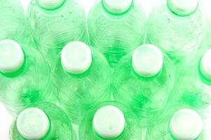 el plastico botellas son dispersado en un blanco superficie foto