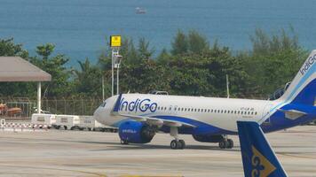 Phuket, Tailandia febbraio 26, 2023 - passeggeri aereo airbus a320 di indaco su il aeroporto, rullaggio per parcheggio. aereo indiano le compagnie aeree arrivo nel Phuket video
