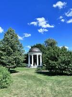 un Kiosko en un parque con arboles y césped foto