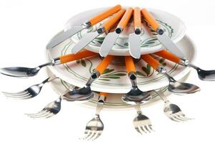 un apilar de platos con cucharas en parte superior foto