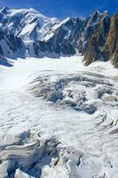 two people are hiking up a mountain with snow covered mountains photo