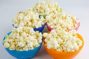 four colorful bowls of popcorn on a white surface photo