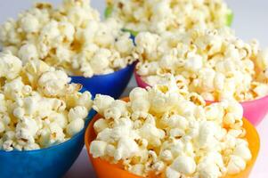 four colorful bowls of popcorn on a white surface photo