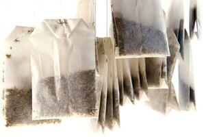 a pile of tea bags on a white surface photo