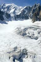 two people are hiking up a mountain with snow covered mountains photo