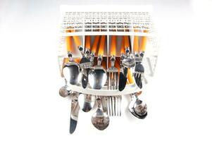 a white dish rack with orange and silver utensils photo