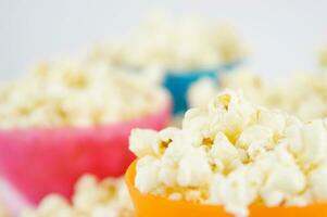 four colorful bowls of popcorn on a white surface photo