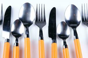 a white dish rack with orange and silver utensils photo