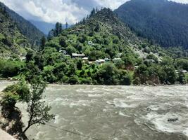 Beautiful day time view of Keran Valley, Neelam Valley, Kashmir. Green valleys, high mountains and trees are visible. photo