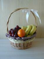 Composition with assorted fruits in wicker basket isolated on white photo