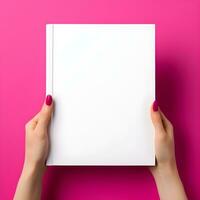 Woman hand holding book with blank cover on pink background, top view. generative ai photo