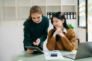 Two business workers talking on the smartphone, tablet and using laptop at the office. photo