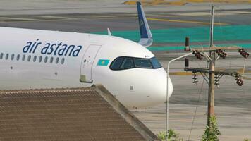 PHUKET, THAILAND FEBRUARY 26, 2023 - Passenger aircraft Air Astana taxiing at Phuket airport, side view. Airplane on apron, airfield video