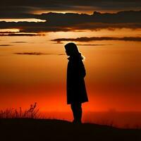 Silhouette of a lonely woman stands alone photo