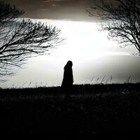 Silhouette of a lonely woman stands alone photo