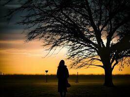 Silhouette of a lonely woman stands alone photo