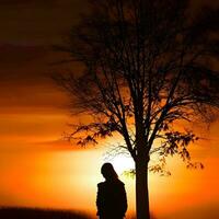 Silhouette of a lonely woman stands alone photo