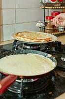 Cocinando crepe suzette panqueques en fritura pan en gas cocina. grasas panqueques con mantequilla foto