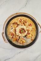 White fish fillet in wine sauce and millet porridge on plate on wooden board photo