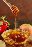 Rosh hashanah - jewish new year holiday concept. Bowl in the shape of an apple with honey, apples, pomegranates, shofar on wooden vintage background photo