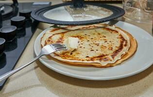 Cooking Crepe Suzette pancakes in frying pan on gas stove photo