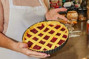 Chef makes cherry pie in his home kitchen photo