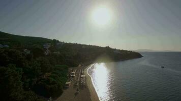 antenn se av tillflykt med solsängar på de Strand i ljus Sol ljus, grekland video