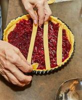 Chef makes cherry pie in his home kitchen photo