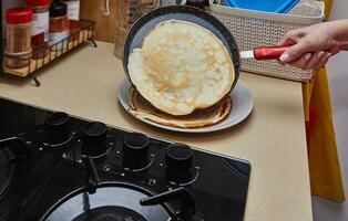 Cooking Crepe Suzette pancakes in frying pan on gas stove photo