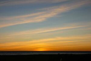 Sun setting over the sea, sunset in autumn on the beach of Zahara de los atunes, Cadiz, Andalucia, Spain photo