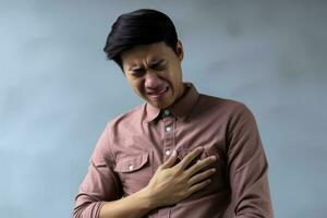 asiático joven hombre con flatulencia úlcera experiencias estómago dolor desde comida envenenamiento o gastritis foto