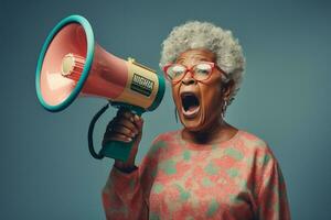 Happy senior woman holding megaphone on bright color background photo