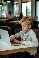 Boy studying with a laptop and notebook photo