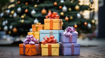 Colorful gift boxes and ribbons stacked under a tree. photo