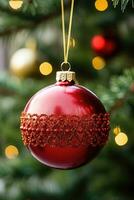 Close-up of a red and gold Christmas ornament on a tree photo
