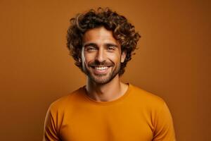 Handsome man with curly hair happily poses against brown background photo