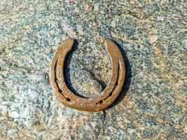 A rusty horseshoe on a stone background texture. photo
