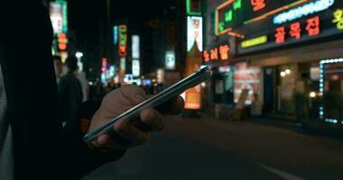 Woman browsing online on cell in night Seoul, South Korea video