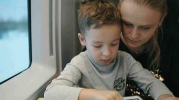 criança jogando jogos em almofada quando viajando de trem com mãe video
