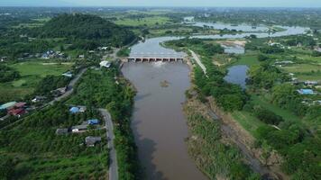 antenne visie van water vrijgelaten van de afvoer kanaal van de beton dam is een manier van overlopend water in de regenachtig seizoen. top visie van troebel bruin Woud water stromen van een dam in Thailand. video