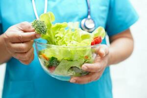 asiático nutricionista participación sano comida para paciente en hospital, nutrición y vitamina. foto