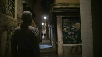 Woman wandering in dark alleyway at night video