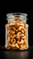 Cashew nuts in a glass jar on a black background AI Generated photo