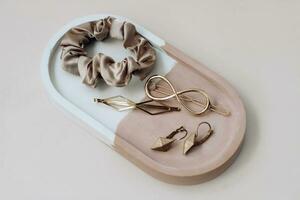 Gold jewelry with silk elastic bands in a plaster organizer photo