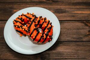 Donuts in black and orange glaze, a dish for Halloween photo