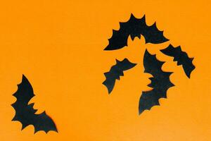 Paper bats on an orange background, Halloween concept photo