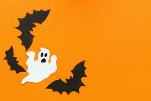 Paper ghosts on an orange background, Halloween concept photo