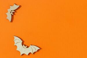 Wooden toy bats on orange background Halloween concept photo